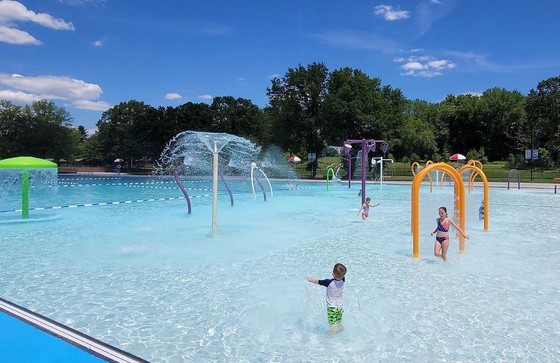 Kids playing at a pool splash pad area