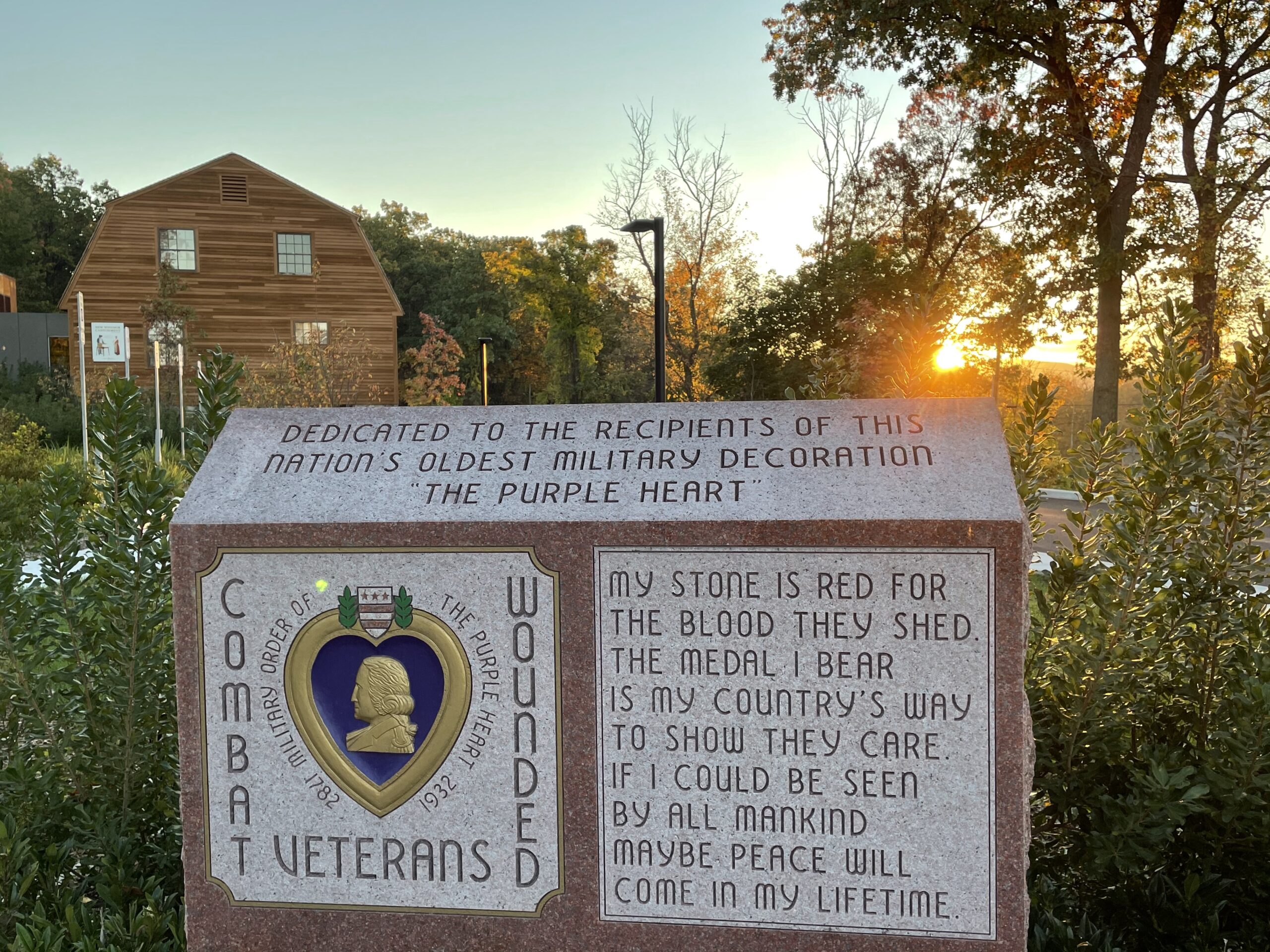 A sign with veterans information with a sunrise behind